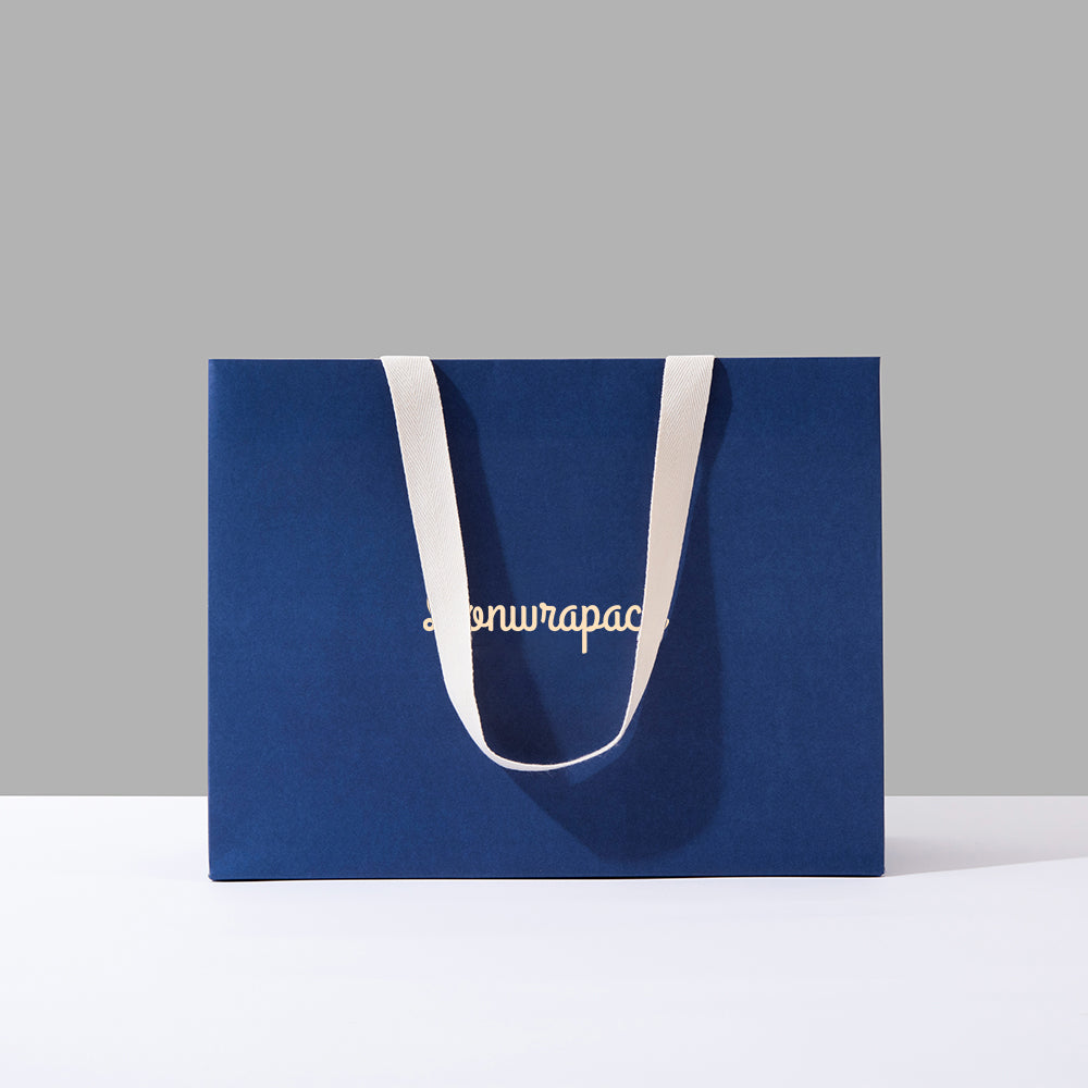Blue paper shopping bag with white handles and a white logo