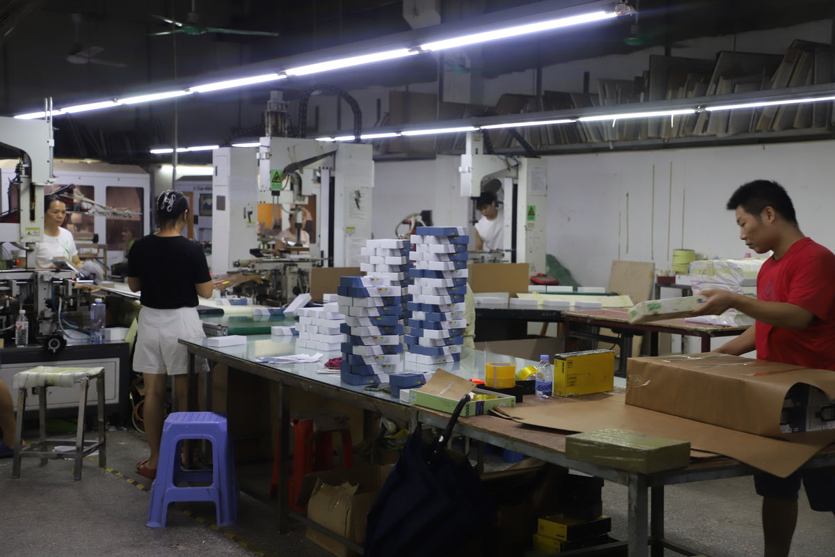 paper box packaging factory production workshop with packing tables and forming equipment