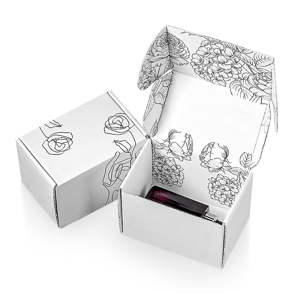 White floral printed mailer box shown open with a small cosmetic bottle inside.