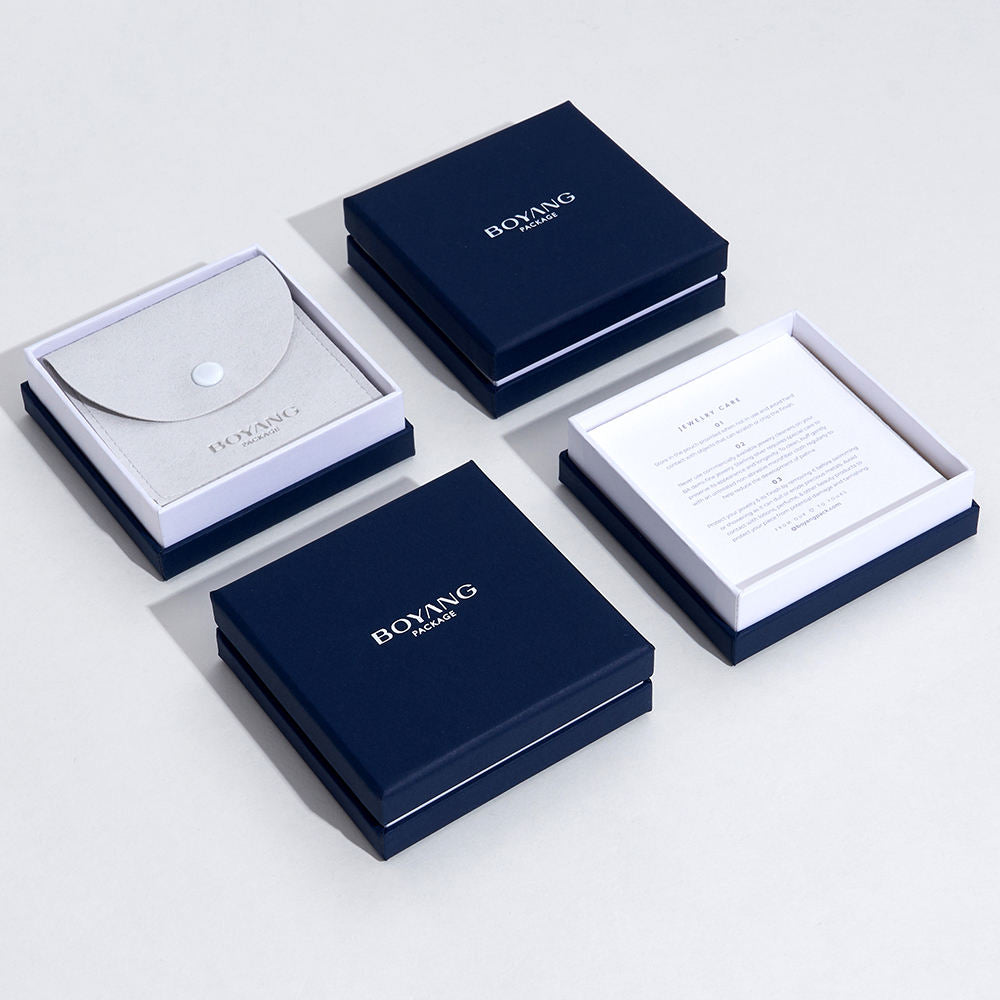 Navy and white lid-and-base jewelry boxes arranged with a white presentation insert.