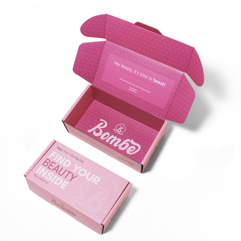 Open pink cosmetic mailer box with printed interior branding and a matching closed package.