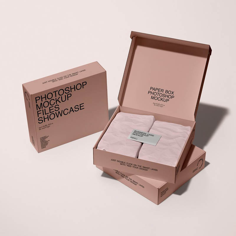 Open blush pink printed mailer box with tissue paper and a matching closed box.